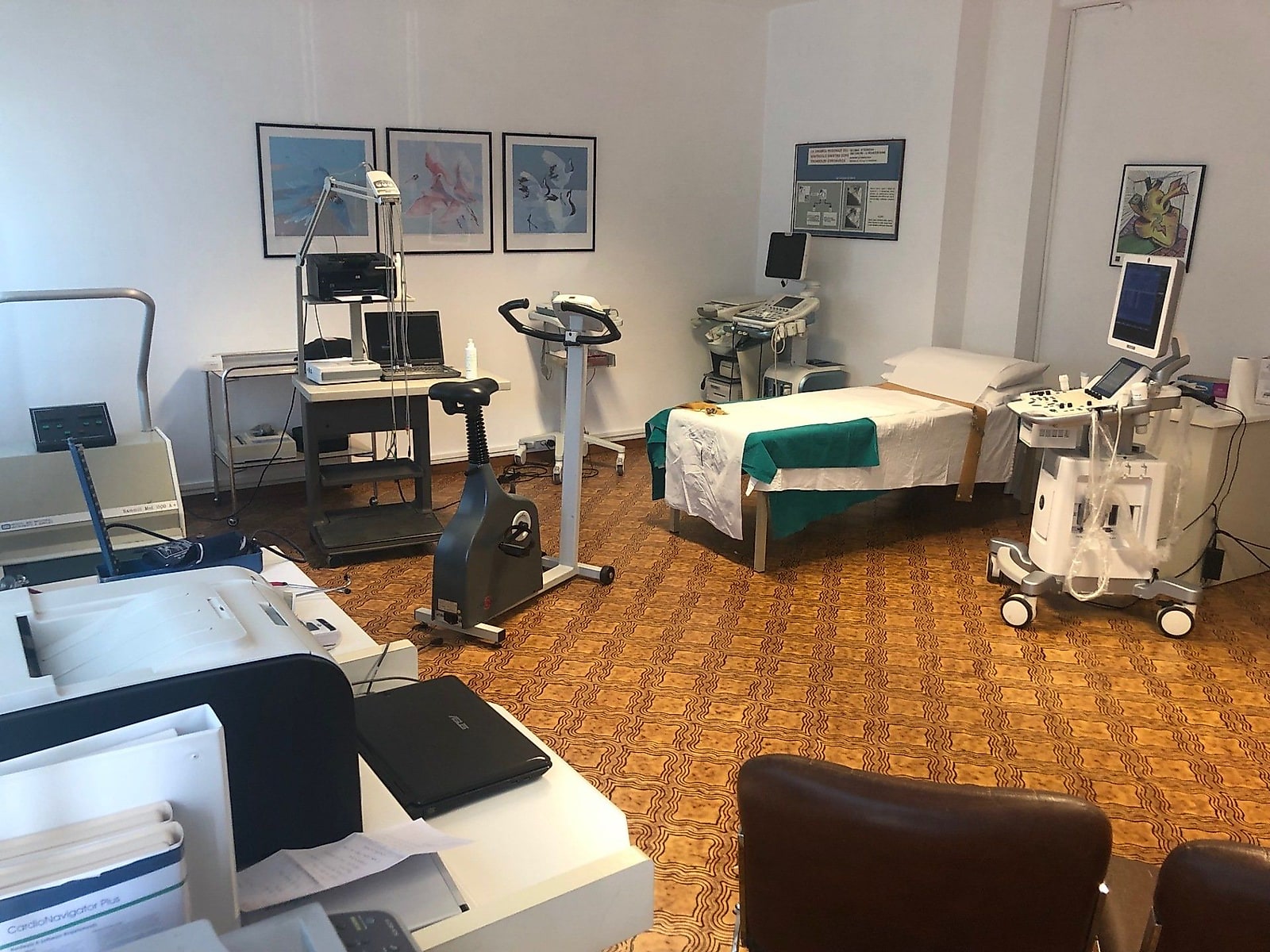 L'ambulatorio cardiologico: il lettino per l'ecocardiogramma, il cicloergometro per il test da sforzo e l'ecografo